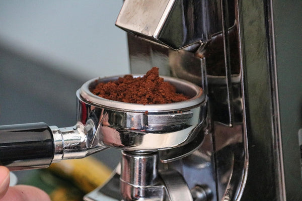 Coffee grinder with freshly ground coffee showing grind texture