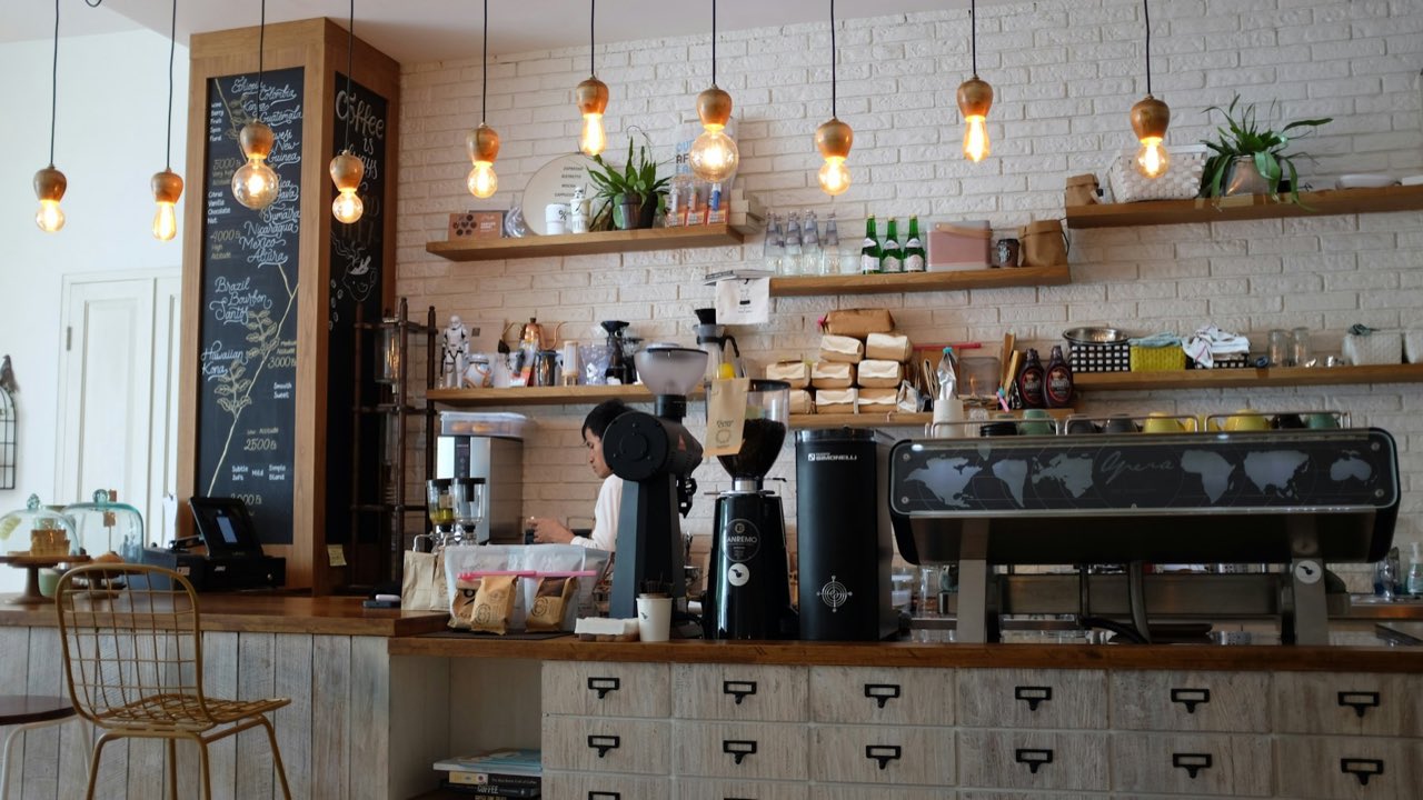 A specialty coffee bar with a barista at the espresso machine